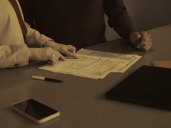 Two people seated at a table reviewing documents together.